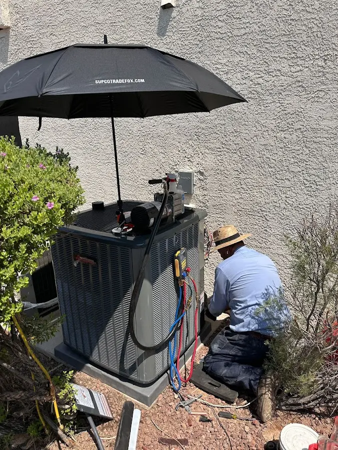 HVAC technician performing outdoor AC maintenance in East Riverdale